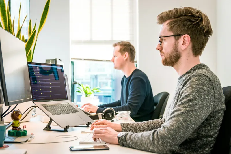 Two developers at their desks building a custom platform